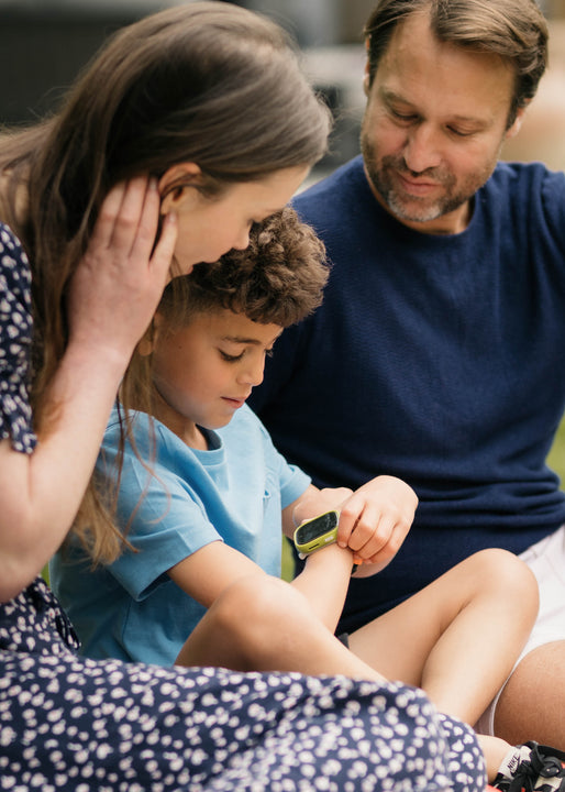 Parents help their child set up his first kids smartwatch so he can call & message them